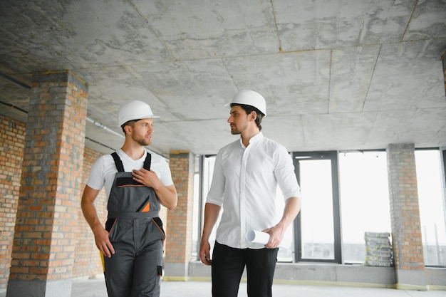 Architecte masculin donnant des instructions à son contremaître sur le chantier