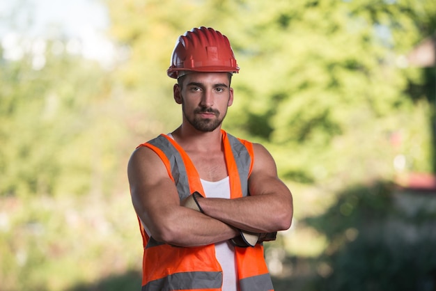 Architecte masculin réussi sur un chantier avec les bras croisés