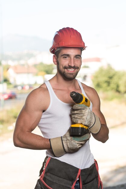 Architecte masculin réussi sur un chantier avec perceuse