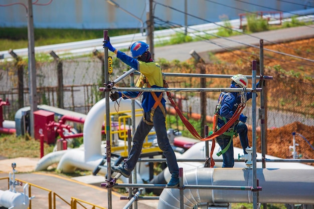 Architecte sur les ouvriers du chantier sur un pipeline d'échafaudage