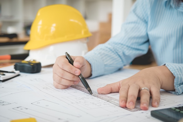 Architecte ou planificateur travaillant sur des dessins pour les plans de construction à une table