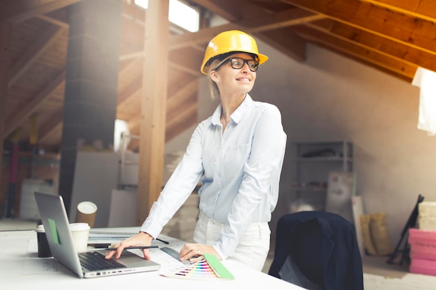 Architecte portant un chapeau de protection alors qu'il travaille sur un chantier de construction