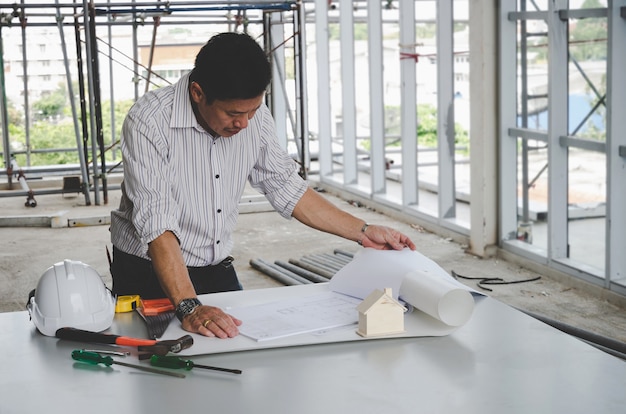 Architecte professionnel, ingénieur ou dessin d'intérieur avec plans et outils sur la table de conférence dans le centre de bureau sur le chantier de construction,