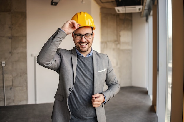 Architecte réussi debout sur le chantier et regardant la caméra.