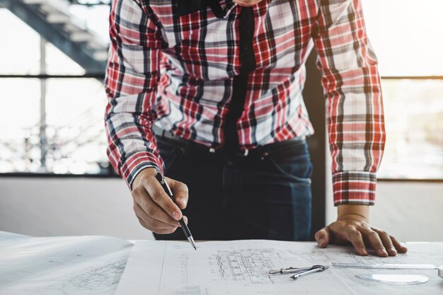 L'architecte de la section centrale travaille sur un plan au bureau.