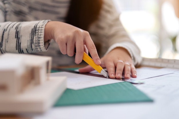 Un architecte travaillant et coupant des papiers au bureau