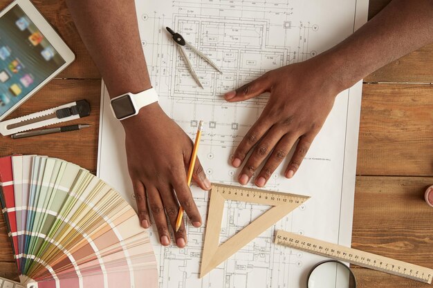 Architecte travaillant sur une vue de dessus de plan d'un homme afro-américain dessinant quelque chose sur un