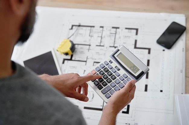 Architecte utilisant une calculatrice pour calculer la surface utilisable