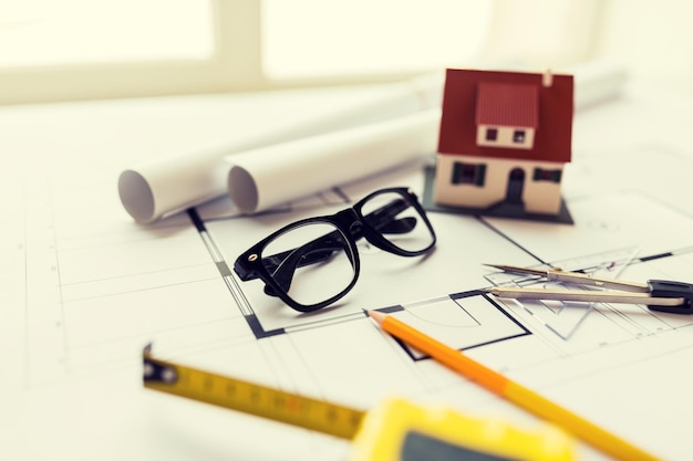 architecture, bâtiment, construction, immobilier et concept de maison - gros plan d'un plan avec modèle et outils de maison d'habitation