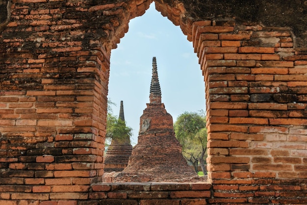 Architecture historique de la Thaïlande ruines de l'ancienne capitale du Siam Ayutthaya Vue sur les stupas du temple Wat Pra Si Sanphet depuis la fenêtre du mur de briques