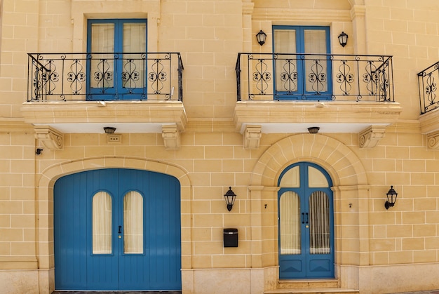 Architecture de Malte, façade d'une maison avec des fenêtres en bois et un balcon bleu sur l'île de Malte