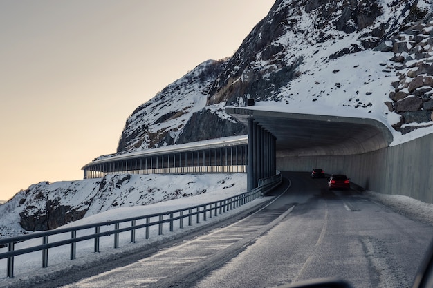 Architecture de la route du tunnel avec voiture roulant à travers la montagne de neige en hiver aux îles Lofoten, Norvège