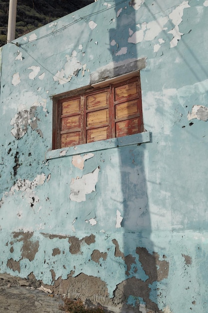 Architecture d'un vieux mur bleu avec peinture écaillée à l'extérieur Détails de la texture extérieure d'une ancienne construction résidentielle rustique avec des fenêtres fermées en bois d'époque découvertes à Santa Cruz de La Palma