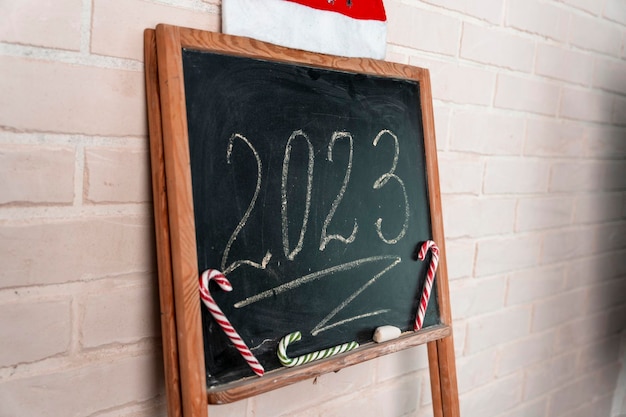 Une ardoise noire sur laquelle l'année 2023 est écrite à la craie Bonne année