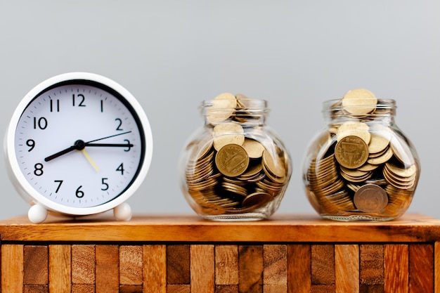 Photo argent de la banque de pièces et temps d'économiser de l'argent sur le temps gagner un revenu salaire concept d'épargne
