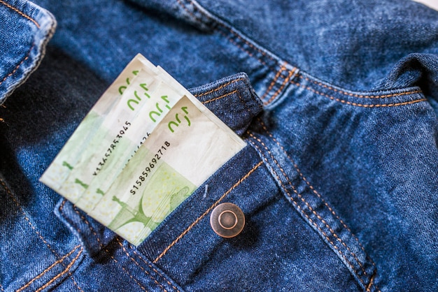 L&#39;argent dans la poche. Gros plan de cent billets en euros en poche jeans.