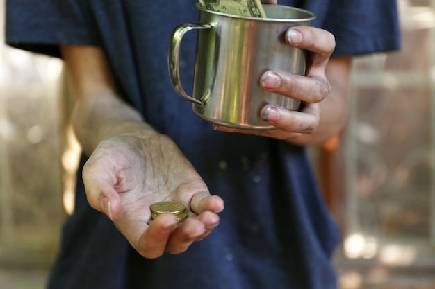 L'argent du mendiant sans-abri sur ses mains sales