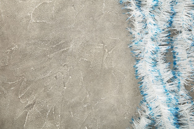 Argent de Noël et guirlandes bleues sur table en béton gris