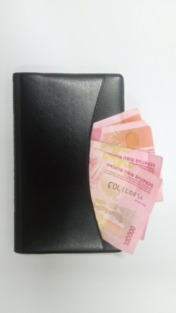Photo argent plié dans la poche du livre de poche isolé sur fond blanc, la roupie est la monnaie de l'indonésie