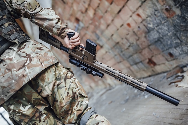 L'armée tient un casque et un fusil dans ses mains.