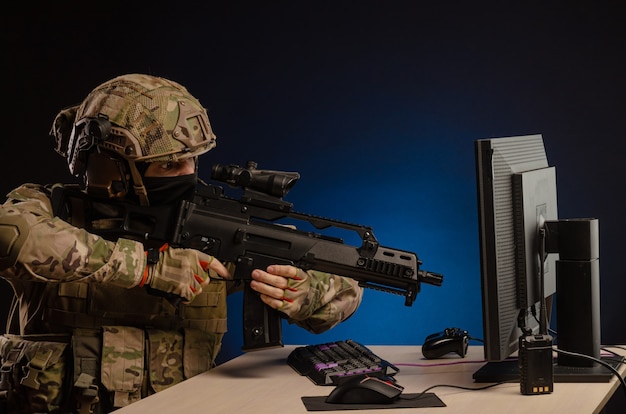 L'armée en uniforme assis devant un ordinateur mène une cyberguerre