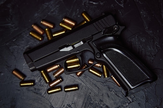 Photo armes à feu sur fond sombre vue de dessus d'un pistolet et de balles pistolet pour la défense ou l'attaque concept de