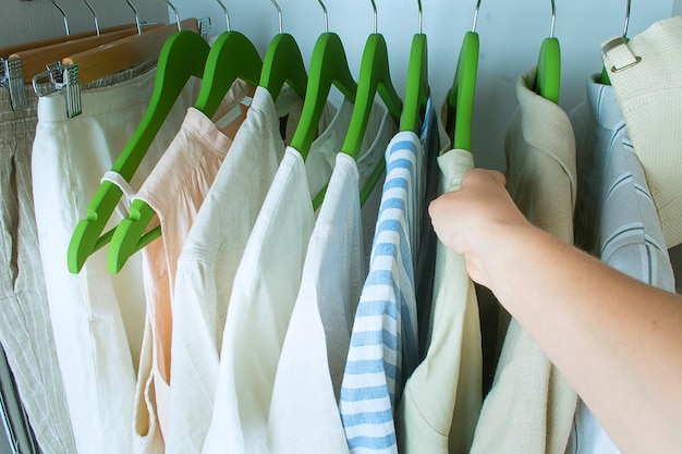 Armoire d'été avec vêtements en lin sur cintres verts