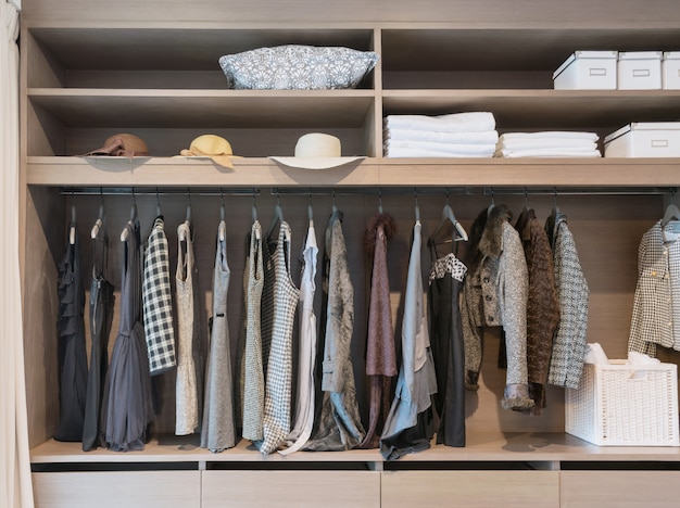 Armoire moderne avec rangée de robes suspendues au cintre dans la penderie.