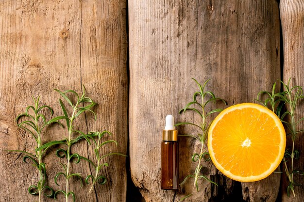 Arôme essentiel de romarin et d'orange bio ou huile cosmétique à partir d'ingrédients frais dans une bouteille en verre avec pipette Concept promotionnel pour la santé de la peau effet anti-stress pour les soins du corps