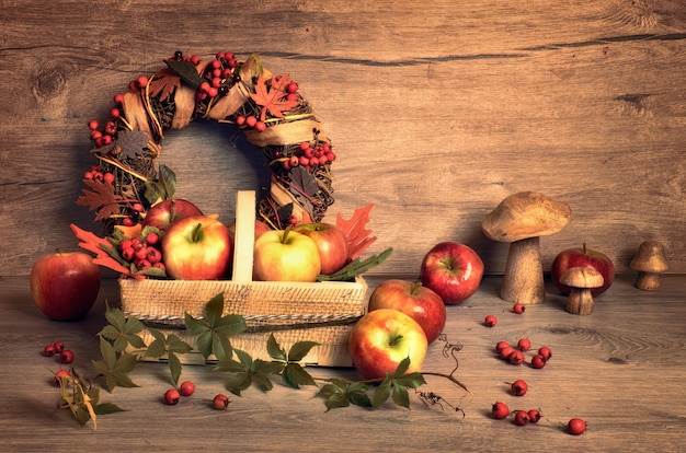 Arrangement d'automne avec des pommes savoureuses, des champignons et une couronne d'automne