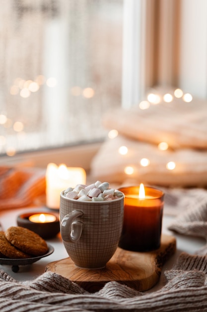 Arrangement de fenêtre chaleureux et confortable concept d'hiver ou d'automne des bougies de café jettent des lumières