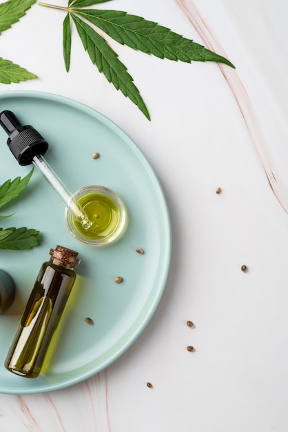 Photo arrangement de feuilles de cannabis et de bouteilles d'huile