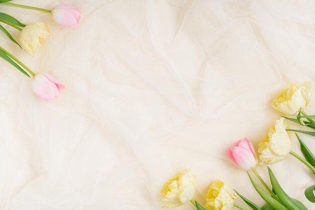 Arrangement de fleurs pour un anniversaire ou la fête des mères Fleurs roses et jaunes sur fond beige saint valentin Mise en page plate vue de dessus espace de copie