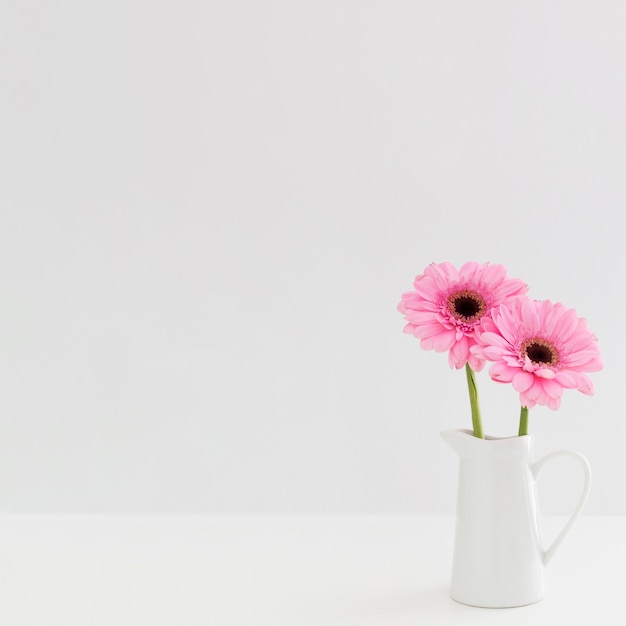 Arrangement de fleurs roses dans un vase blanc