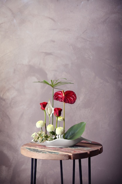 Arrangement de fleurs sur une surface colorée