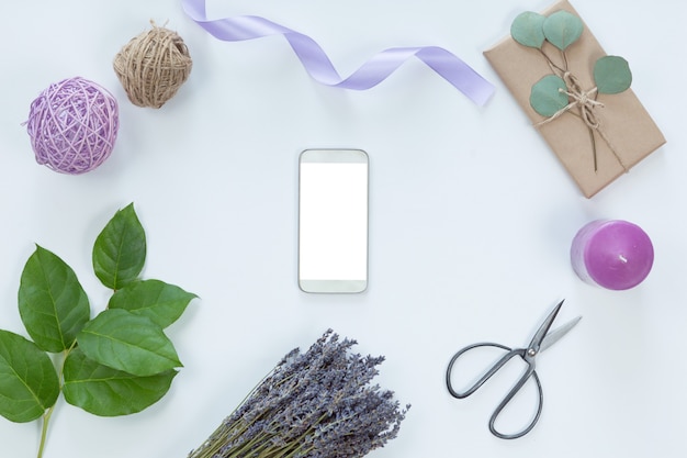 Arrangement de fleurs avec un téléphone portable dans un cadre floral, vue de dessus et pose à plat