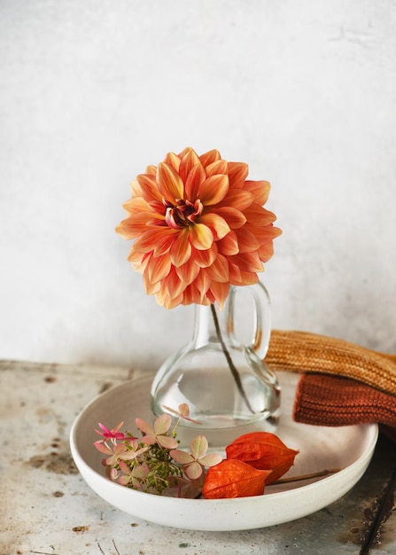 Arrangement floral d'automne avec fleur de dahlia rouge orange dans un vase en verre décoré d'hortensia