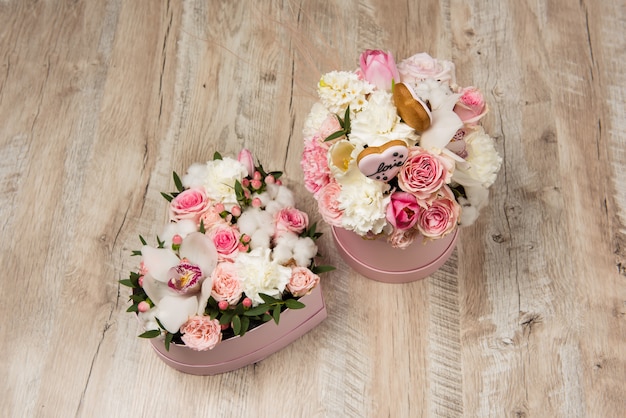 Arrangements floraux dans des boîtes roses