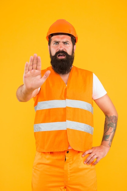 Arrêtez Zone dangereuse Aucune entrée Homme ingénieur uniforme de protection arrêtez-vous Ingénieur constructeur architecte Vêtements de protection pour l'industrie de la construction Ingénieur hipster barbu Ingénieur principal sur le site