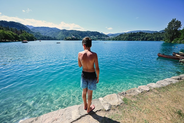 L'arrière du garçon se tenir dans la jetée de voir le magnifique lac de Bled en Slovénie