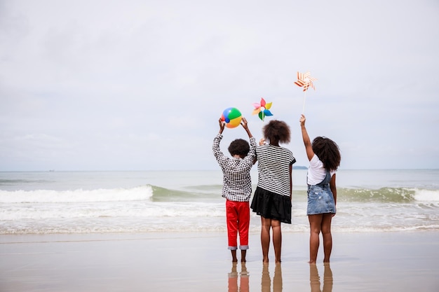 L'arrière des enfants afro-américains debout sur une plage tropicale concept ethniquement diversifié