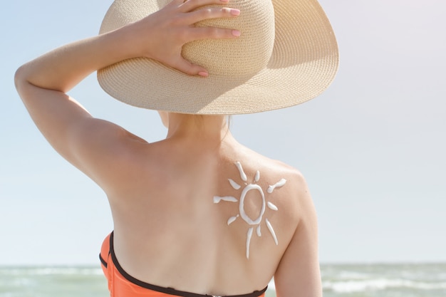 L'arrière d'une fille avec un soleil crème peinte