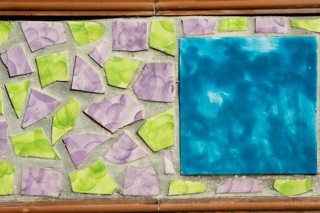 Arrière-plan abstrait en céramique Motifs traditionnels italiens sur carreaux panneaux de peinture artisanale faits de céramique cassée aux couleurs violettes et vertes