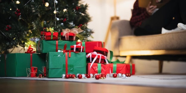 Arrière-plan Arbre de Noël et boîte à cadeaux avec des décorations près d'une cheminée avec des lumières