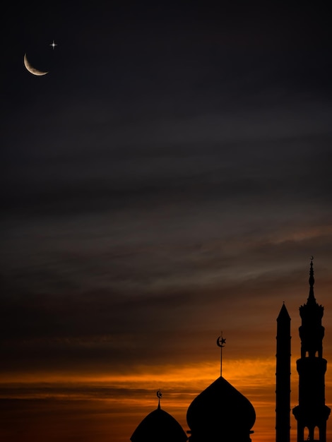 Arrière-plan de l'architecture islamiqueDôme des mosquées avec croissant de lune et étoile sur le ciel doré du soir noir foncé