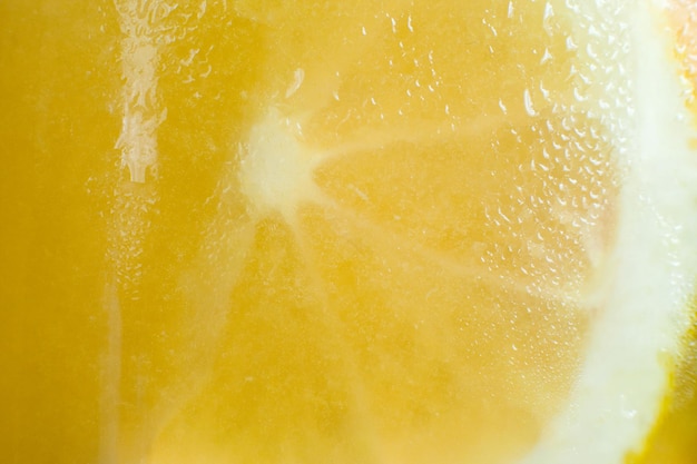 Arrière-plan de cocktail d'agrumes frais et froid Gros plan photo d'un mur de verre de boisson aux fruits avec des gouttes d'eau et un concept de rafraîchissement et de fraîcheur en forme d'orange en tranches