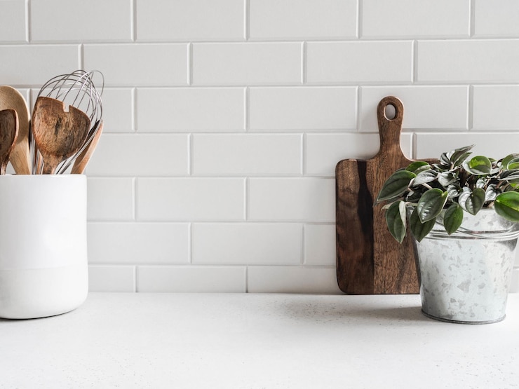 Photo arrière-plan de cuisine blanc élégant avec des ustensiles de cuisine et un comptoir blanc vert de plantes d'intérieur