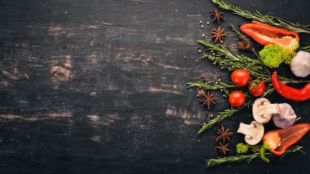 L'arrière-plan de la cuisine Un ensemble d'épices et de légumes frais Vue de dessus Espace libre pour votre texte Sur un fond en bois