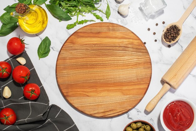 Photo arrière-plan culinaire blanc avec des planches de bois et des ingrédients de pizza