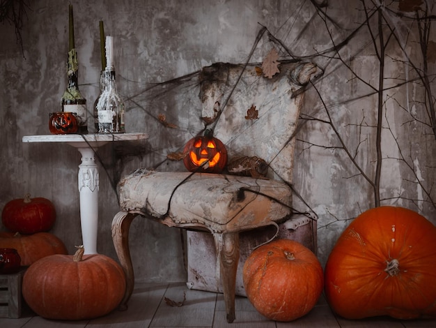 Arrière-plan de décorations pour la célébration d'Halloween Une composition effrayante avec la citrouille de Jack et des bougies allumées des toiles d'araignées et un balai de sorcière sur un mur en béton